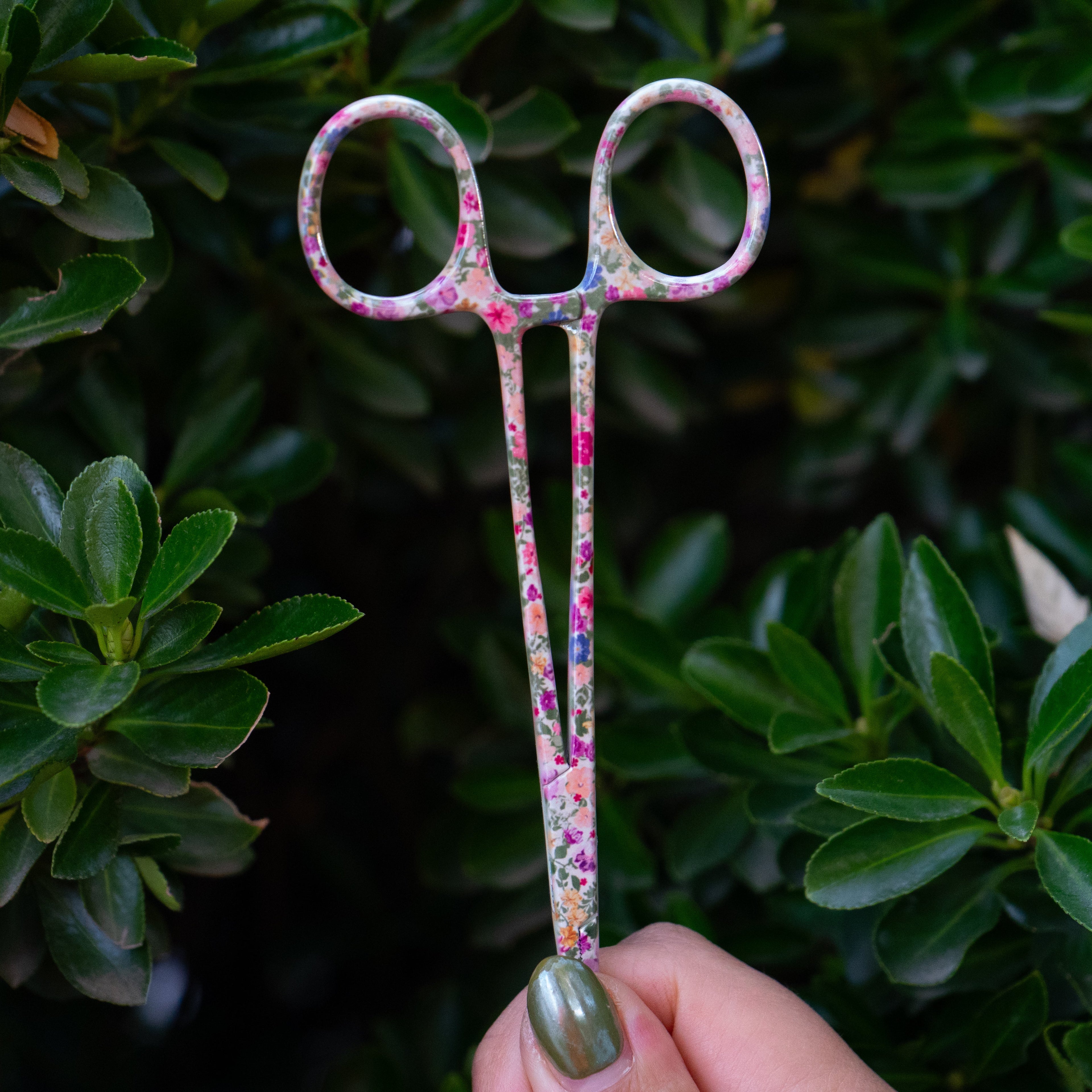 Close-up of Brook Floral Hemostats showing stainless steel build and pink floral pattern, designed for women anglers.