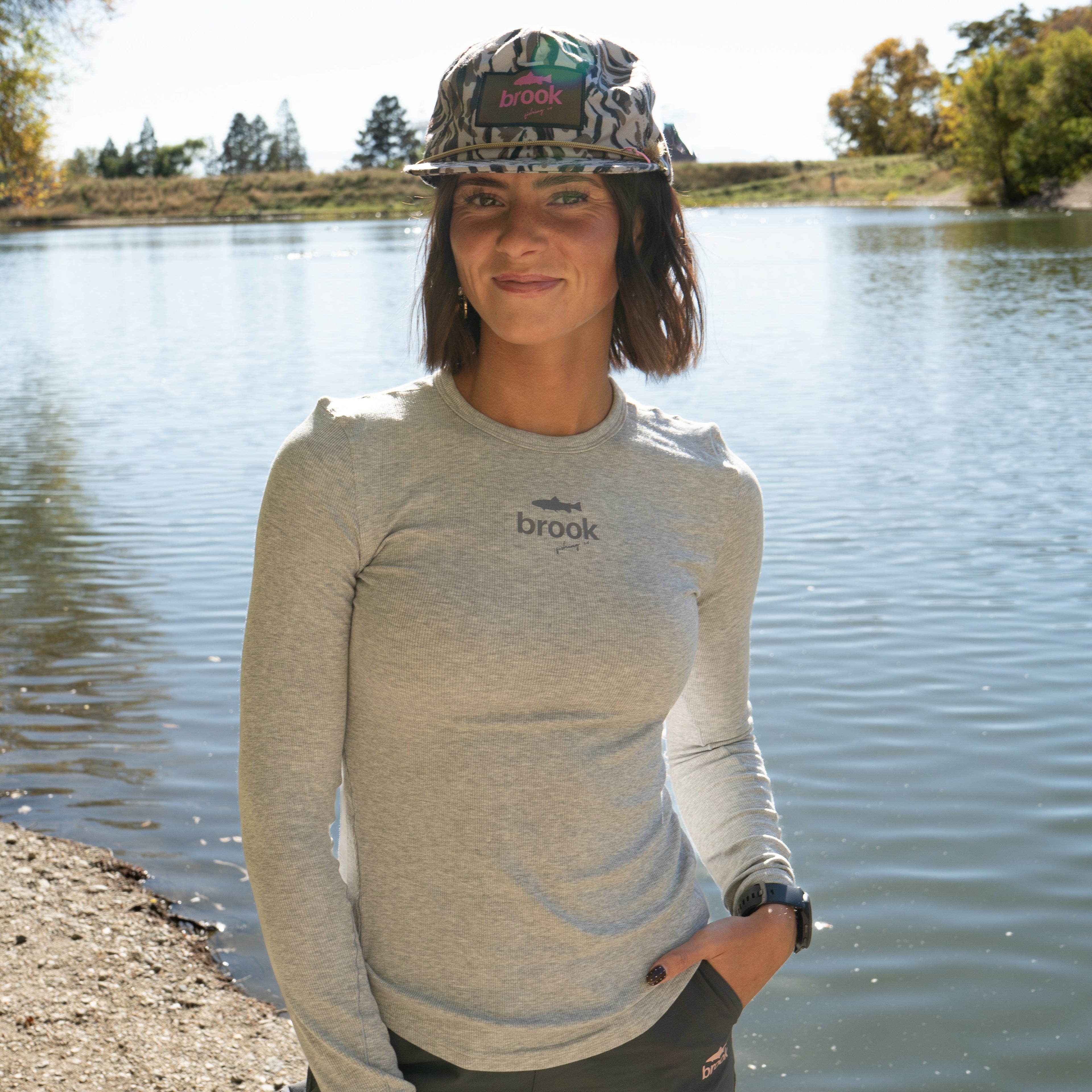 Woman wearing gray Stillwater Modal Tee with tonal logo, showing slim fit and long sleeves for fishing or layering.