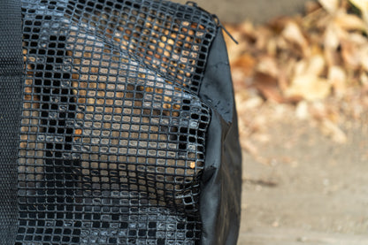 “Close-up of the black PVC mesh on the Brook Fishing Co. gear bag, showing the breathable grid texture with fallen leaves blurred in the background.”
