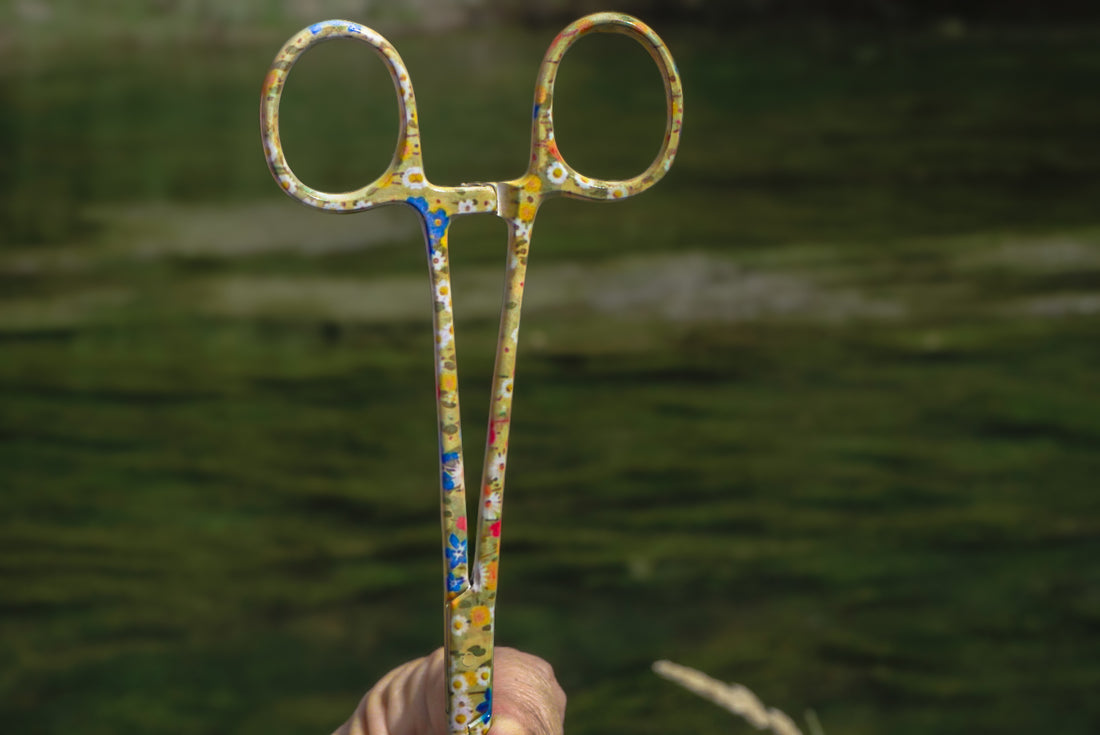 Patterned fly fishing hemostats in our Meadow print, featuring tiny daisies and colorful outdoor-inspired details. A practical fly fishing tool with a unique design.