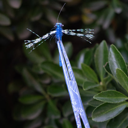 Mini Waves fishing hemostats holding a dry fly at the tip, demonstrating fine control for fly fishing.