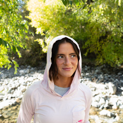 Close-up front view of a woman in the Pink Brook Bamboo Sun Hoodie, hood up, ready for a day of fly fishing.